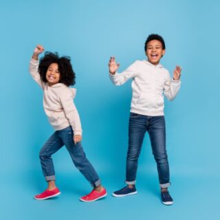 صبي أسمر اللون وبنت سمراء يبتسمون ويقفزون