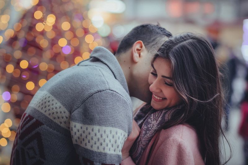 رجل يعانق امرأة وتقبيلها على خدها