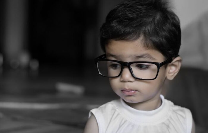 طفل حزين شعره أسود يرتدي نظارة طبية