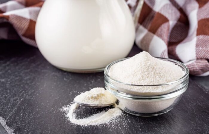 صحن زجاجي وملعقة تحتوي على بودرة بيضاء اللون وبجانبها أبريق زجاجي يحتوي سائل أبيض اللون