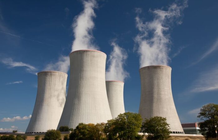 أربعة أعمدة ضخمة مخروطية الشكل لمفاعل نووي يتصاعد منها الدخان