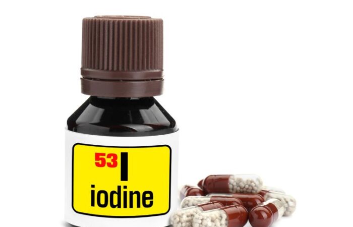 عبوة بلاستيكية صغيرة مكتوب عليها بالإنكليزية iodine ورقم 53 وبجانبها حبوب أدوية