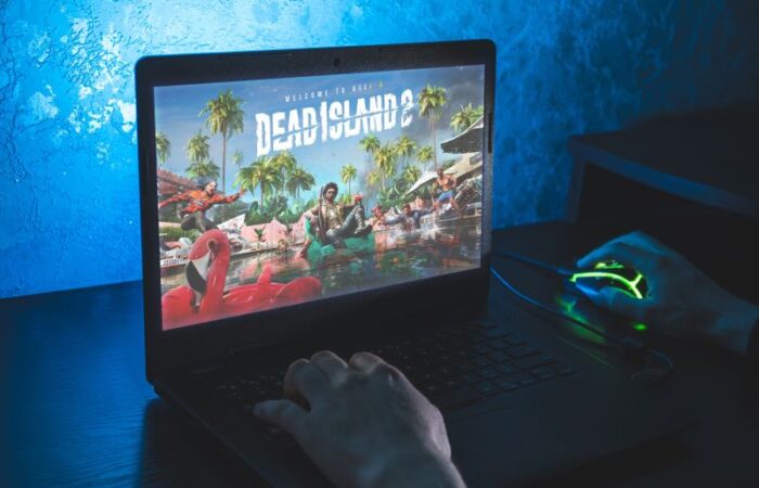 أصابع شخص ينقر على أزرار اللابتوب واليد الأخرى على الفأرة