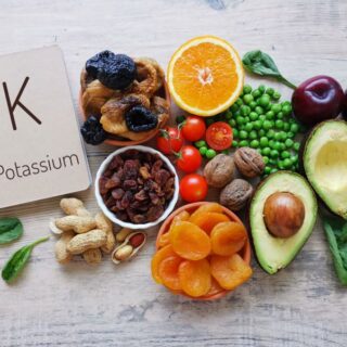 مجموعة من المأكولات كالتين والمشمش والخوخ المجفف، الأفوكادو، والبندورة، وحبوب البازلاء، وحبات الجوز وبجانبهم ورقة بيضاء مكتوب عليها بالإنكليزية حرف K