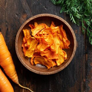 قطعتين من الجزر وبجانبهم صحن صغير يحتوي على شرائح مقطعة من الجزر المجفف