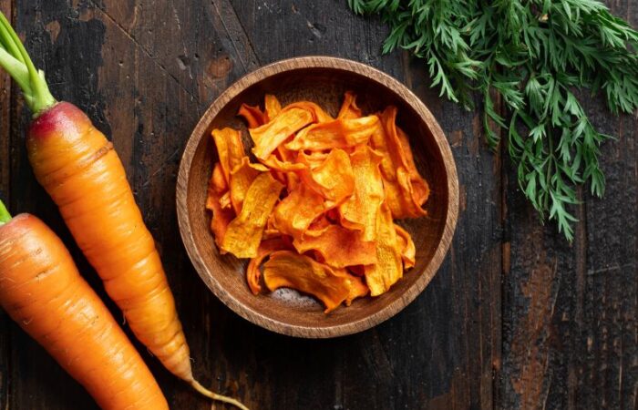 قطعتين من الجزر وبجانبهم صحن صغير يحتوي على شرائح مقطعة من الجزر المجفف