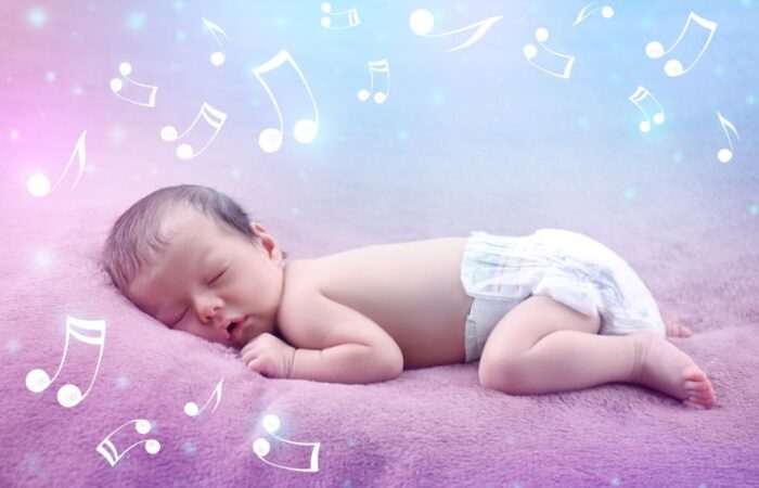 طفل رضيع مستلقي على بطنه وهو نائم وحوله مفاتيح السلم الموسيقي