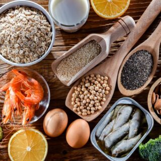 مجموعة من الأطعمة: القريدس، السمك، البيض، الأفوكادو، بذور السمسم، اللوز، الحمص، الشوفان، والورقيات كالسبانخ